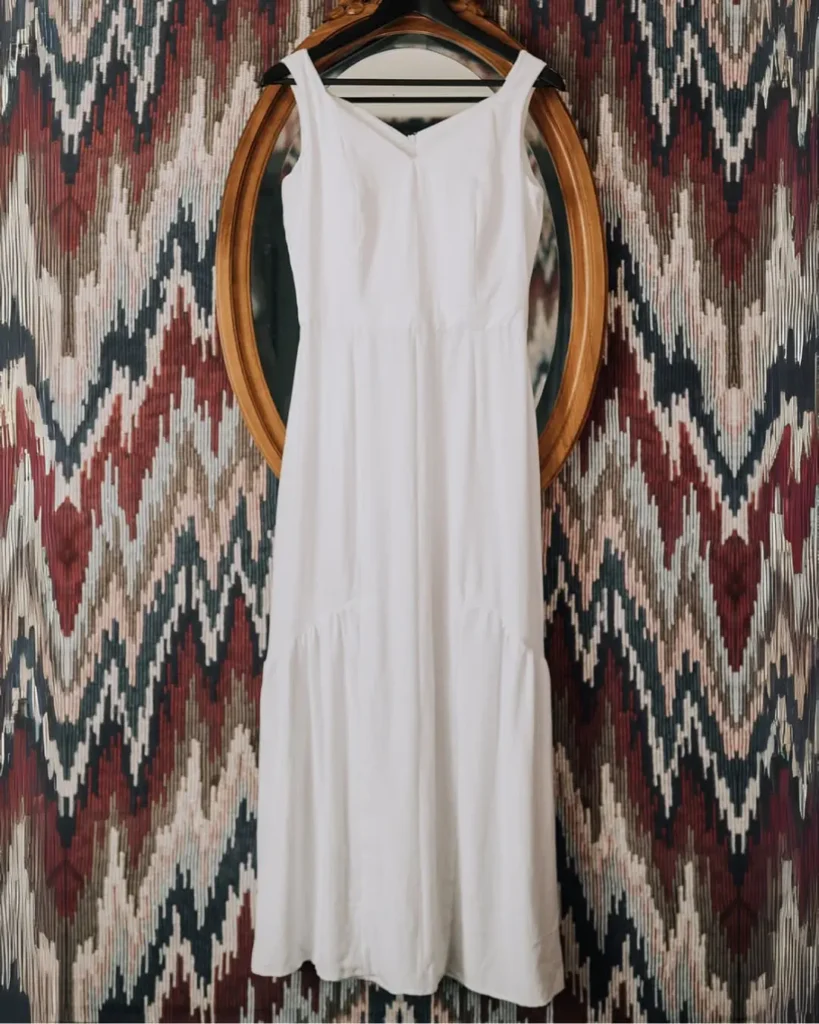 Patron de couture Robe Althéa, cousue dans un tissu blanc et fluide, dans un style bohème chic parfait pour un mariage. Robe longue buste type corset, jupe sirène